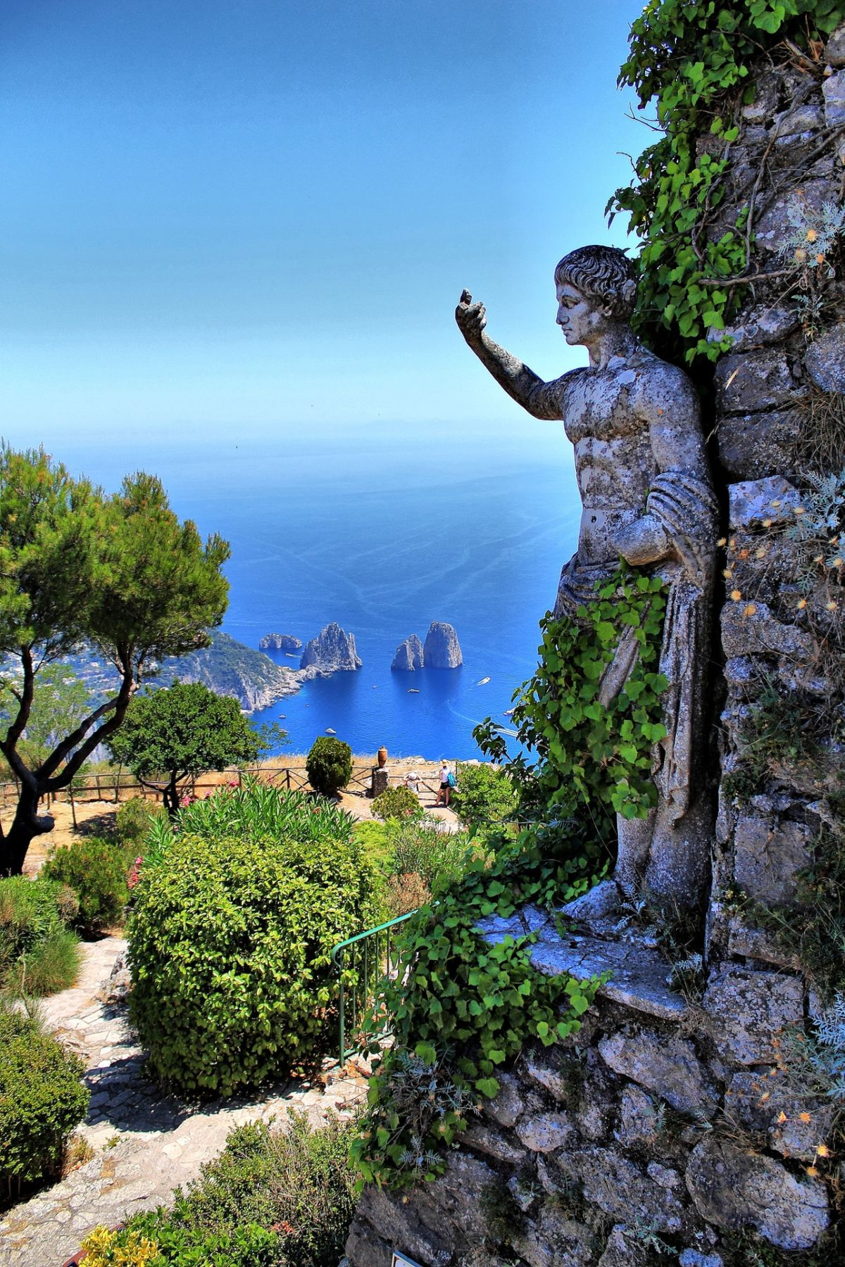 The island of Capri from the sea: the Faraglioni sea stacks rising from the extraordinary blue-green waters of the Bay of Naples