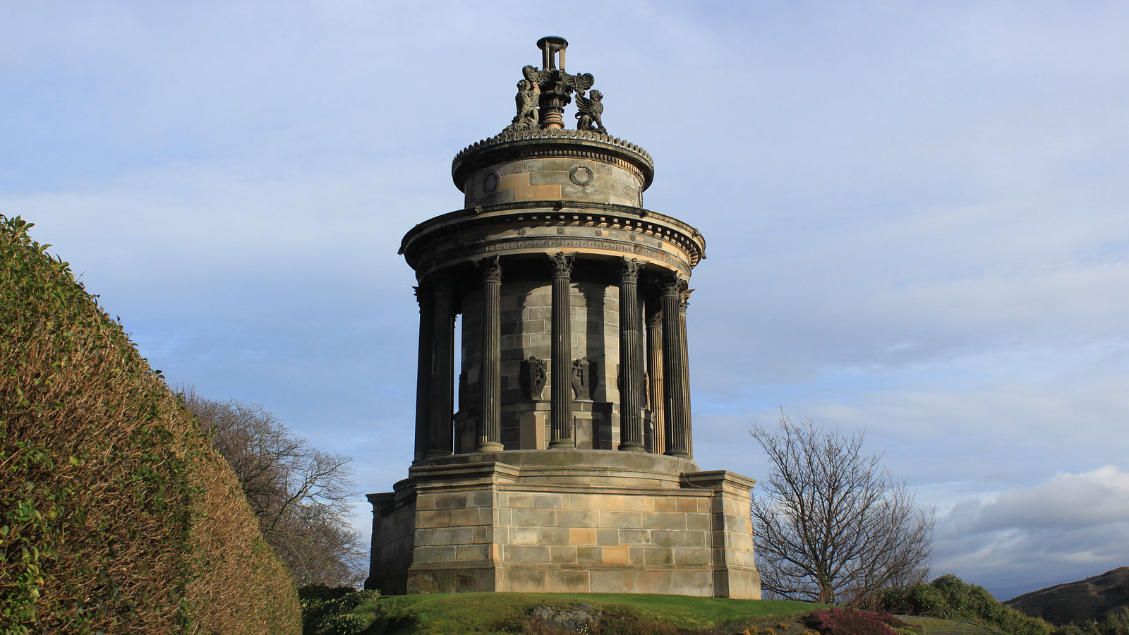 The Burns Monument on Calton Hill in Edinburgh, with the city skyline and Edinburgh Castle visible in the background