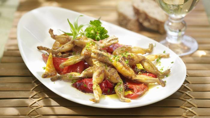 A classic Parisian brasserie terrace in Saint-Germain-des-Prés, with rattan chairs and marble tables under a striped awning