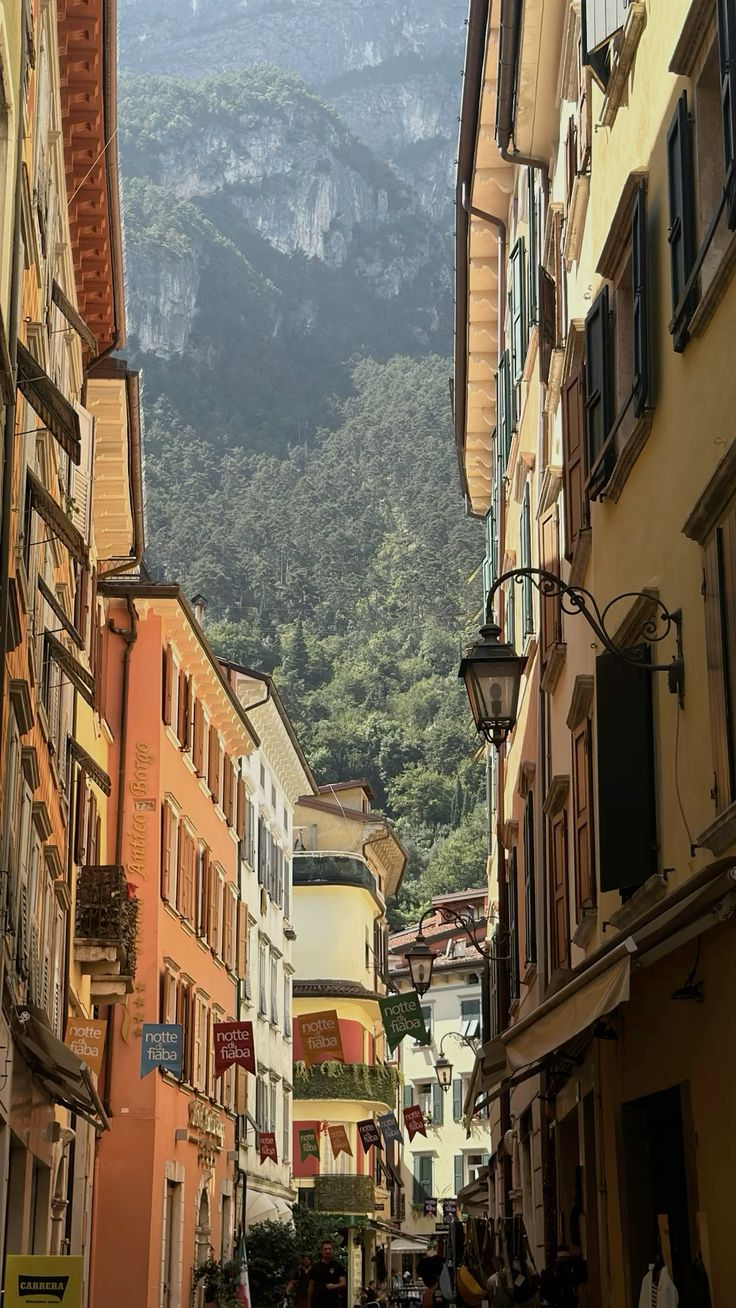 The picturesque town of Riva del Garda at the northern tip of Lake Garda, with the dramatic Alpine peaks of Monte Rocchetta and Monte Brione rising vertically from the water