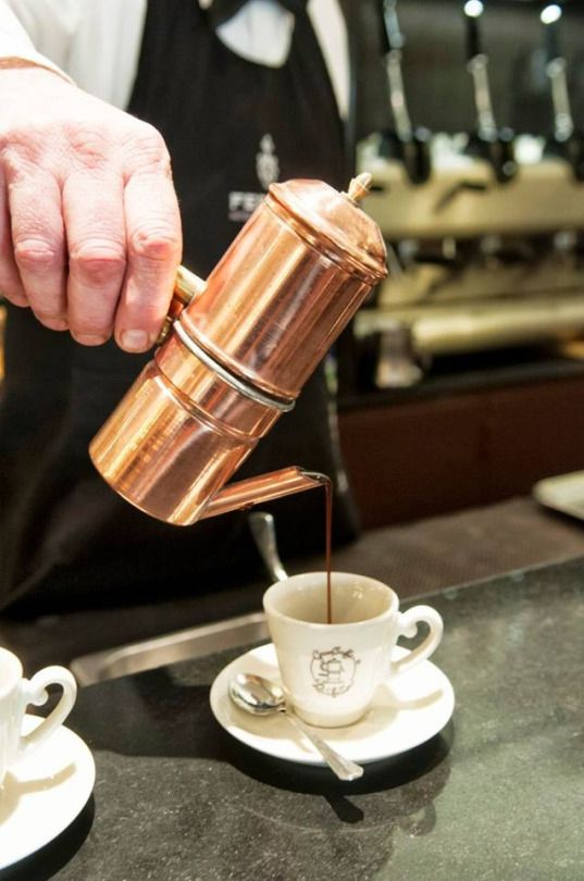 A traditional Neapolitan coffee bar with customers standing at the counter, steam rising from espresso cups, the morning rush captured in a single frame.