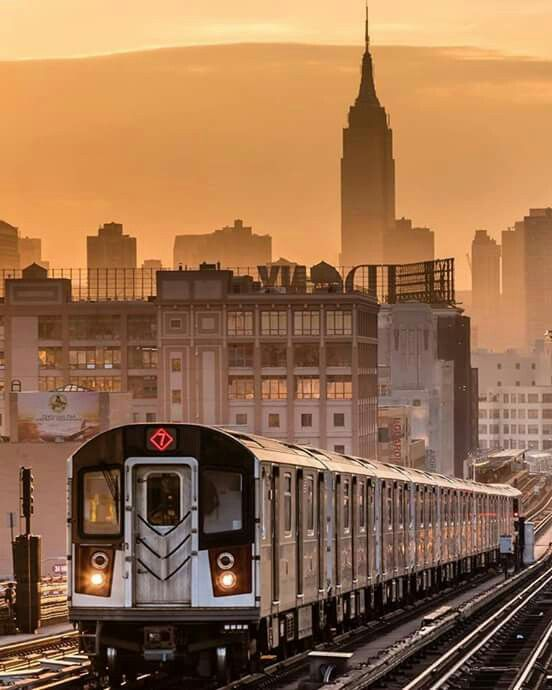 A New York City subway train at a station platform, carrying 1.7 billion passengers per year across 600 miles of track through one of the world's most complex urban transit systems