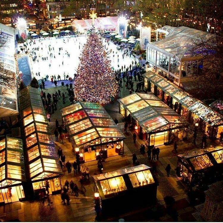 The Bryant Park Winter Village Christmas market in Manhattan, with its 170 vendors, ice skating rink and the Midtown skyline rising above in the winter evening light