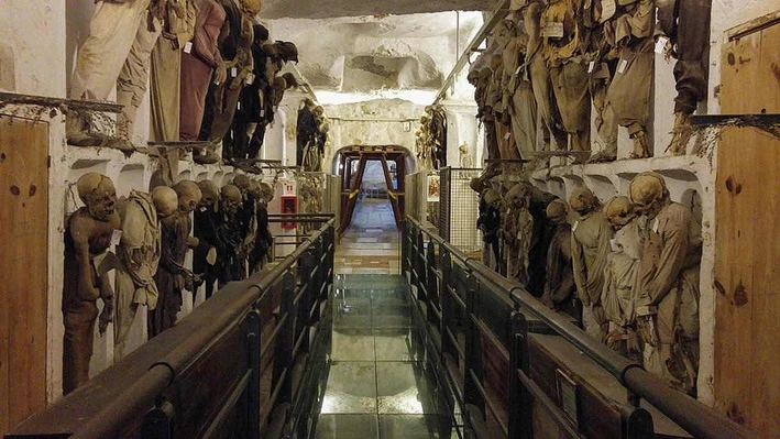 A long corridor in the Capuchin Catacombs of Palermo lined with hundreds of mummified bodies in their original clothing