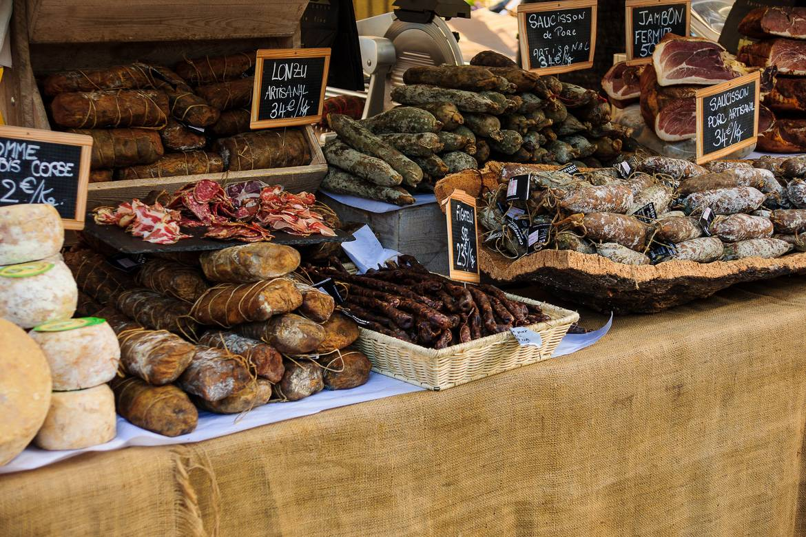 The bustling Rue Mouffetard market street in Paris, lined with cheese shops, bakeries and fruit stalls.
