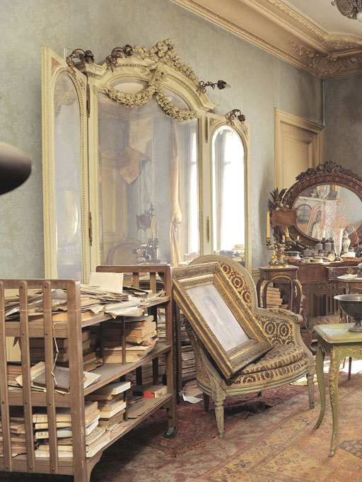 Ornate Louis Philippe style chairs and a marble fireplace, covered in a thick layer of dust inside the de Florian apartment.