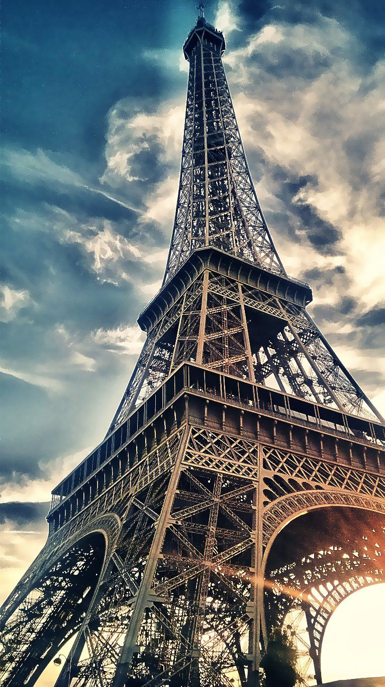 The Eiffel Tower rising above the Seine, seen from the Pont de l'Alma bridge near the Flame of Liberty memorial.