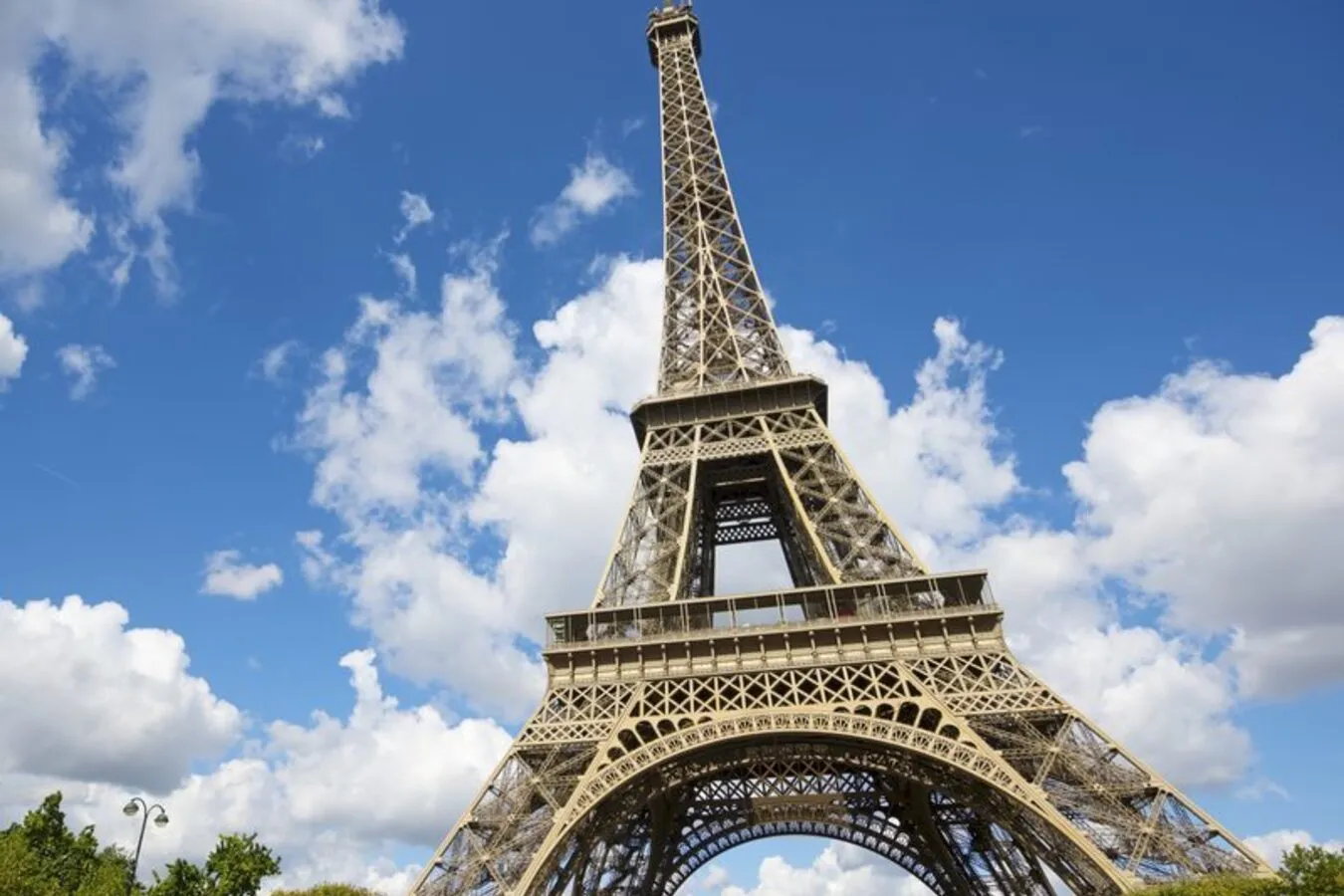 The Eiffel Tower rising above the rooftops of Paris, seen from the Trocadéro with the Seine curving in the foreground.