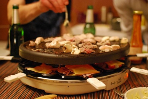 Swiss raclette: melted semi-hard cow milk cheese served with potatoes, gherkins and pickled onions