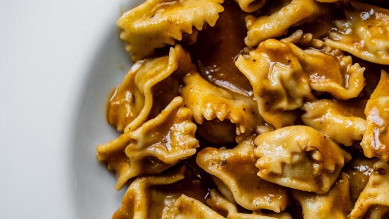 A traditional Piedmontese meal featuring bagna cauda, agnolotti del plin, a bottle of Barolo and gianduiotto chocolates