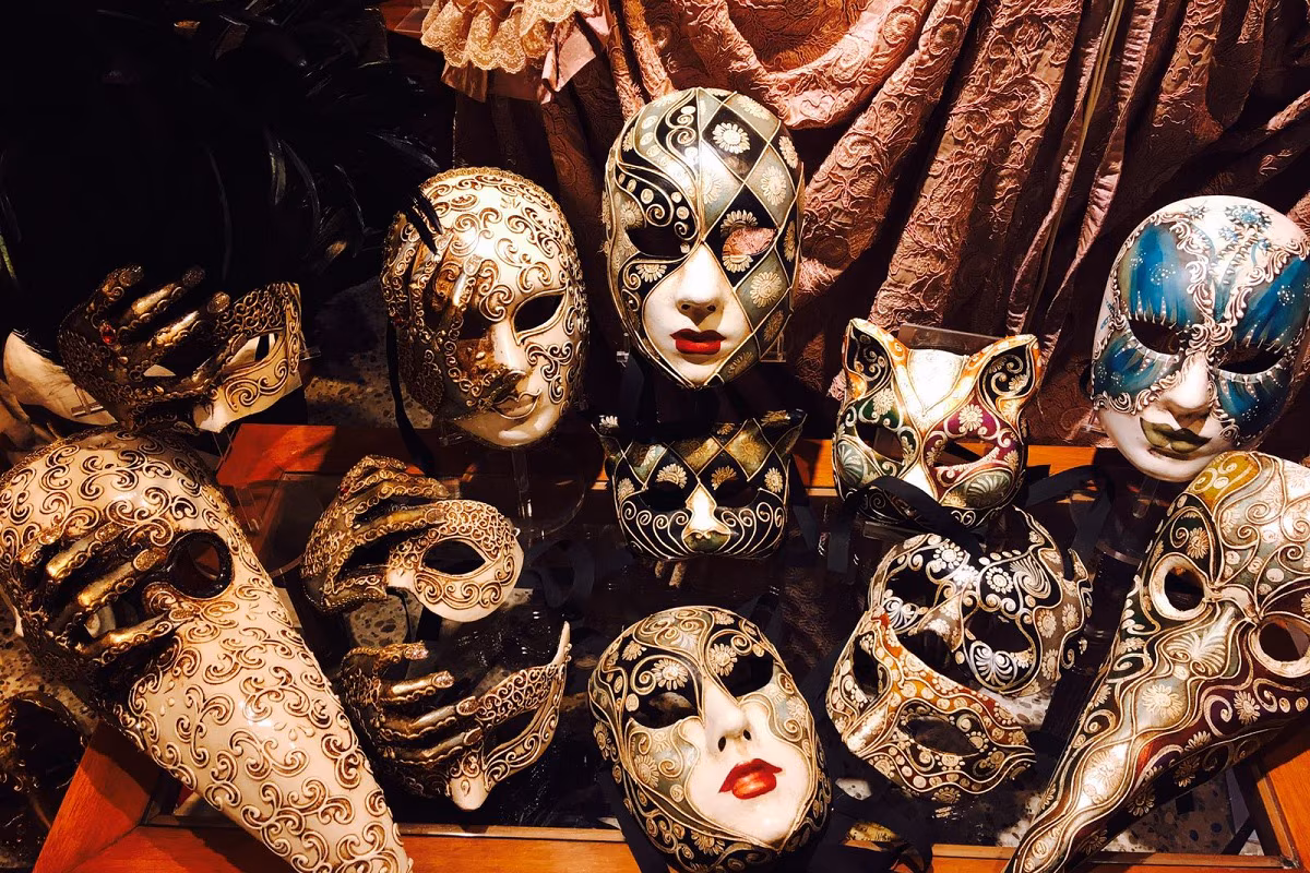 Traditional Venetian masks handcrafted in a historic workshop in Venice, including the white Bauta