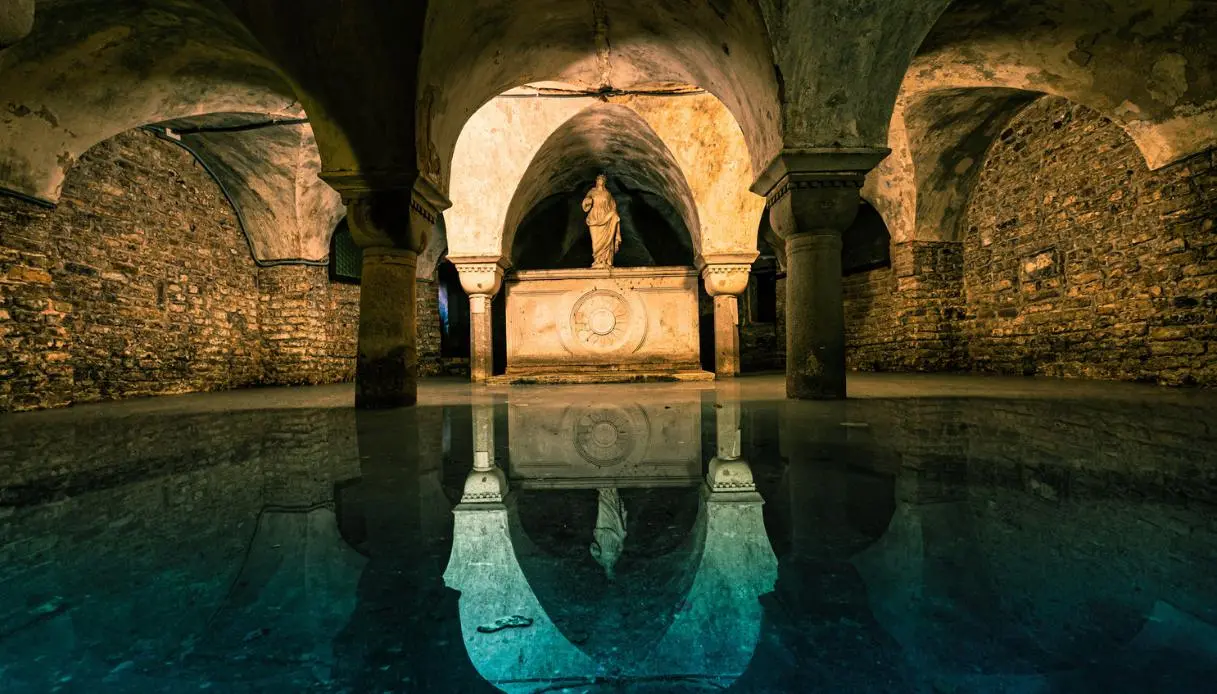 The flooded crypt of San Zaccaria in Venice, tenth-century columns doubled by their own reflection in the still water