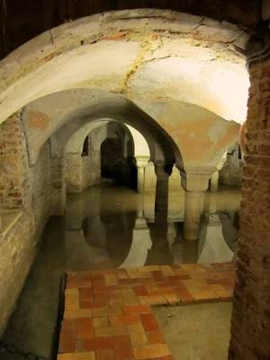 The permanently flooded crypt of San Zaccaria in Venice, tenth-century columns reflected in perfectly still water