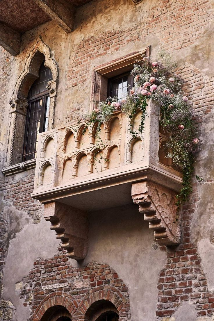 The famous balcony of Juliet's House in Verona, with the bronze statue of Juliet in the courtyard.