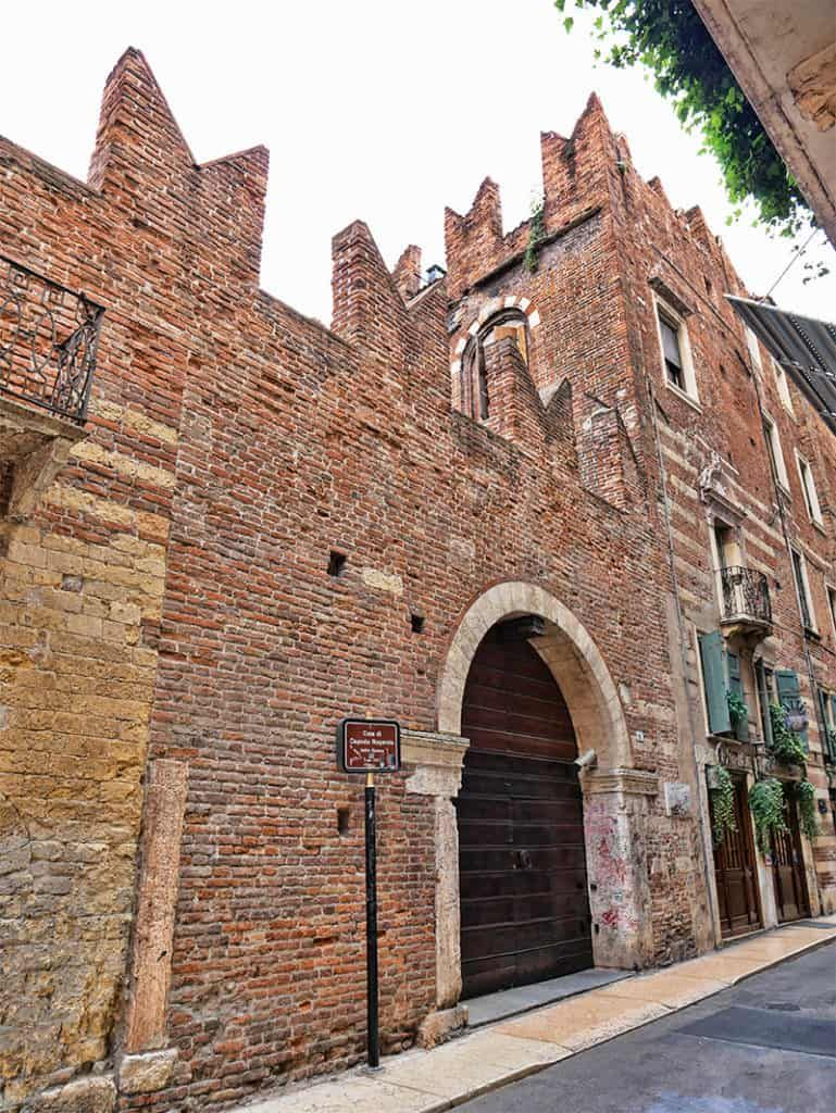 The medieval streets of Verona with the Torre dei Lamberti rising above the red-tiled roofs.